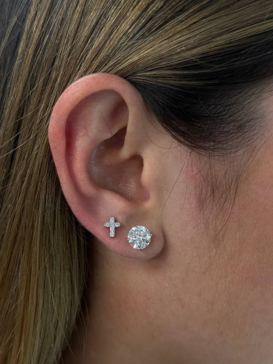Mini cross stud earrings worn